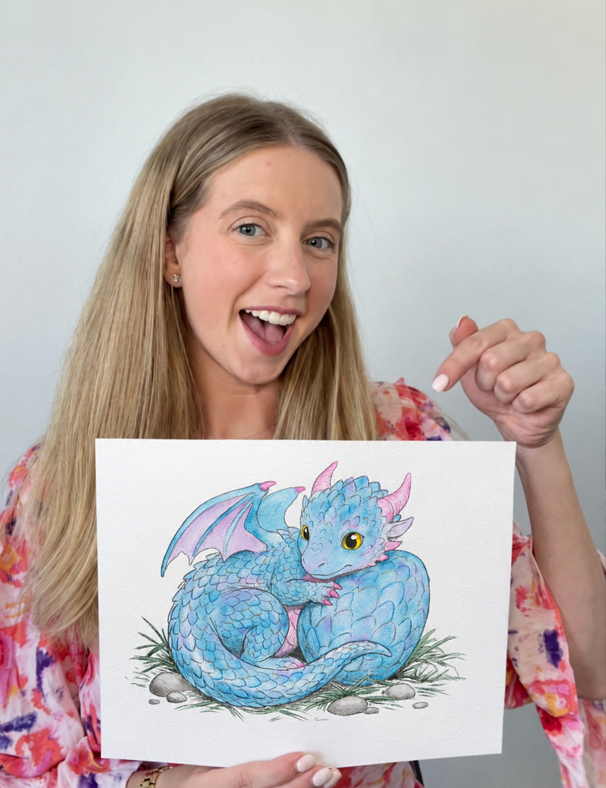 A customer holding her finished watercolor dragon