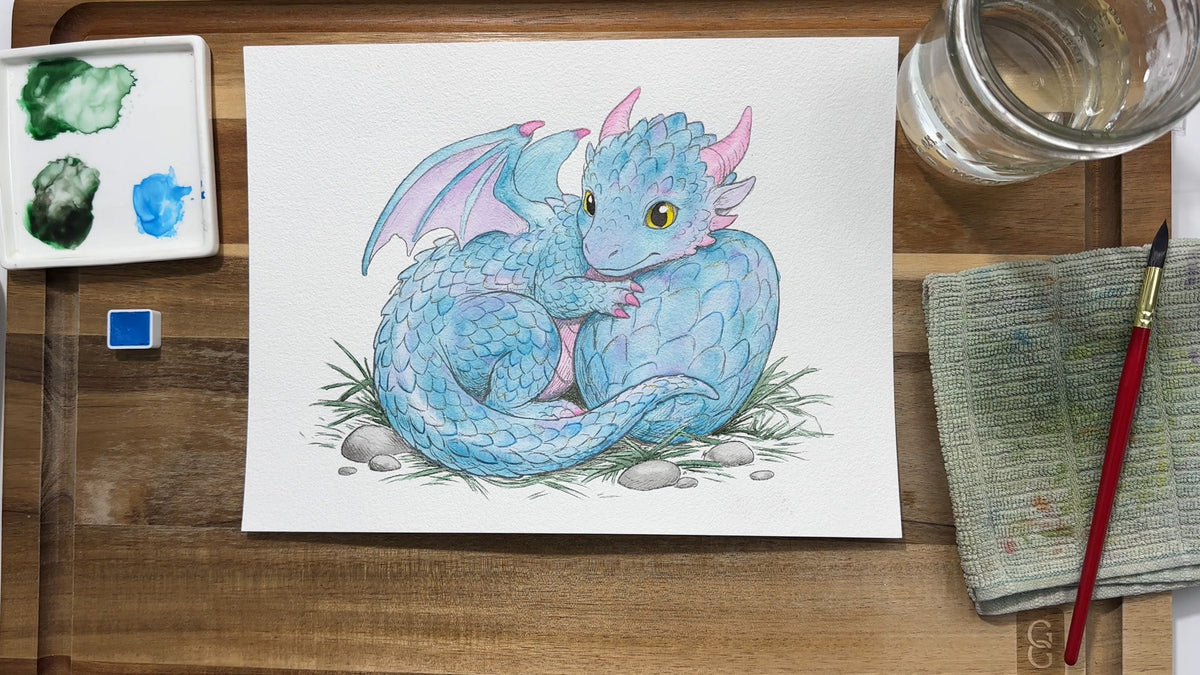 A finished watercolor dragon next to the paints and brushes